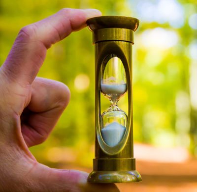 A person holding a small hourglass