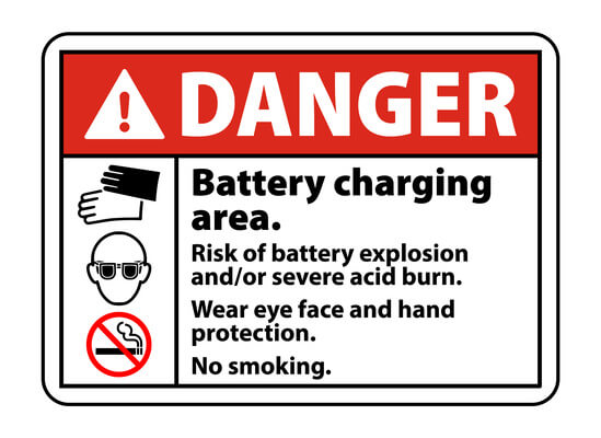 A battery charging area warning sign listing the risks associated with charging batteries