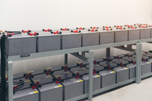 A bank of batteries being stored on metal shelving
