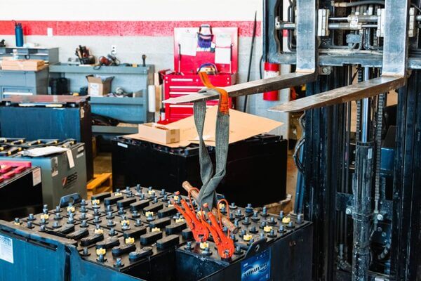 A forklift lifting a battery cell out of a forklift battery