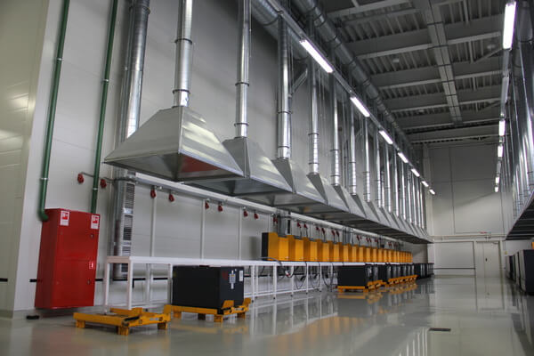 A bank of batteries under fume hoods in a battery charging and storage area