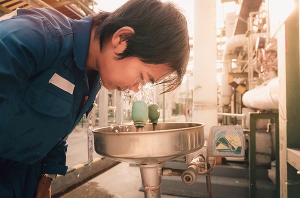 A person using an eye wash station to flush their eyes